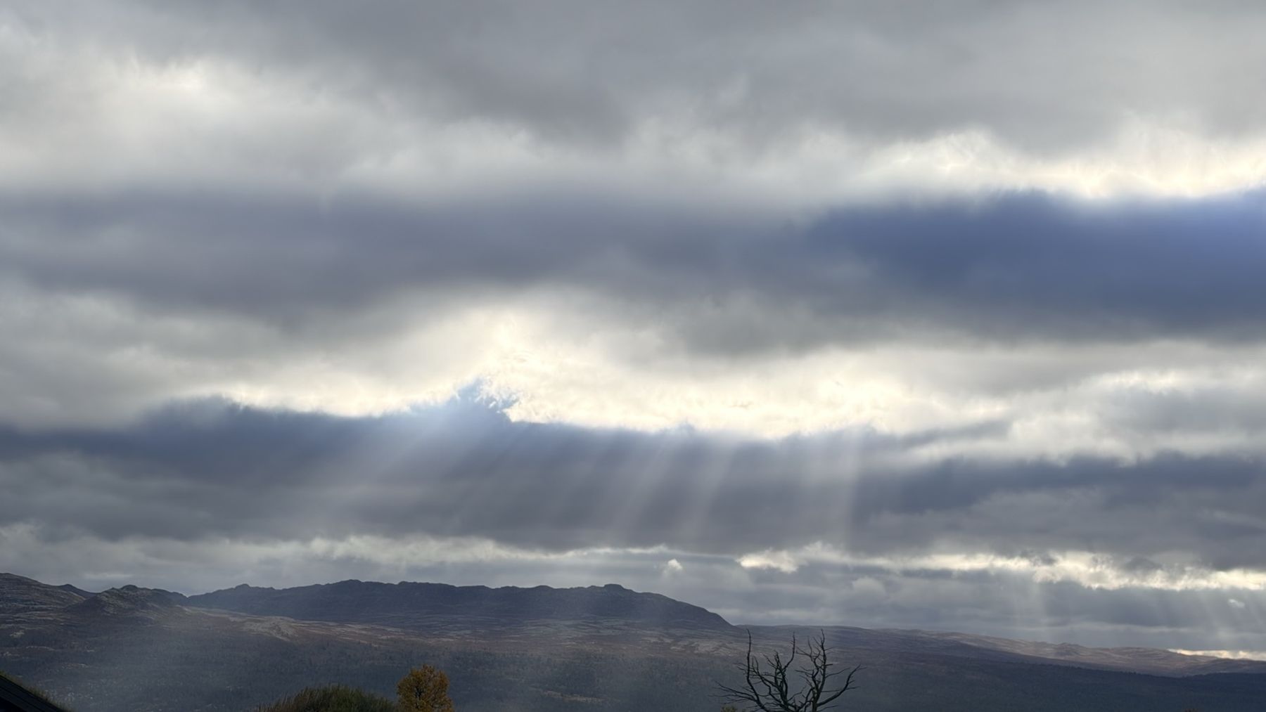 Sun breaking through clouds over Norwegian mountains
