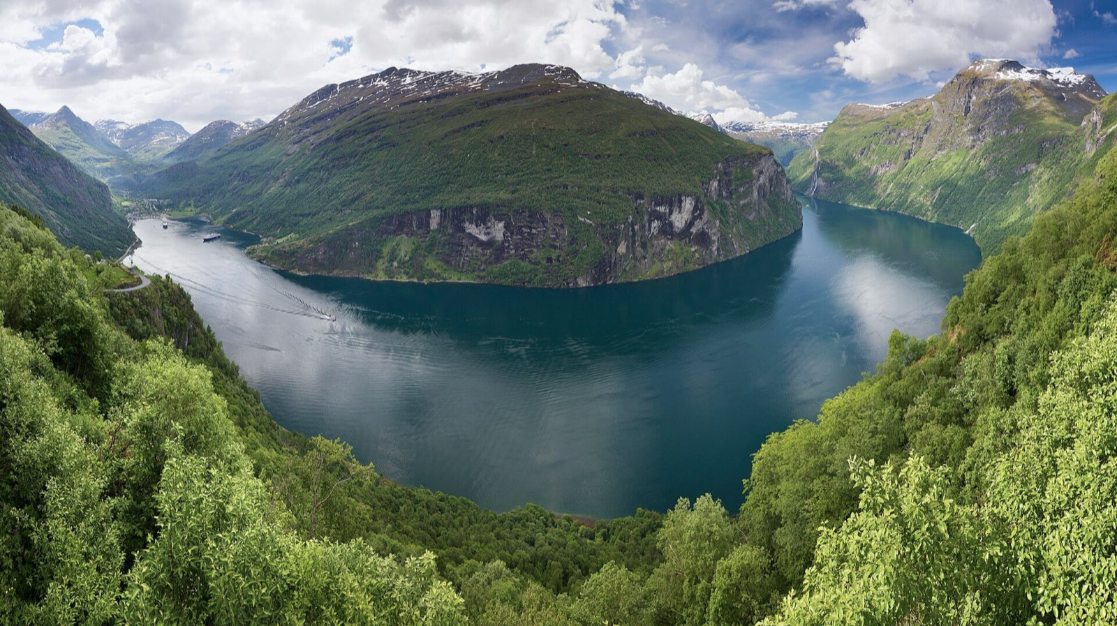 Geirangerfjord in Norway, steep green mountains above still water